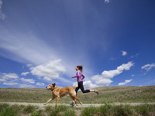 一位女士带着她的狗跑步