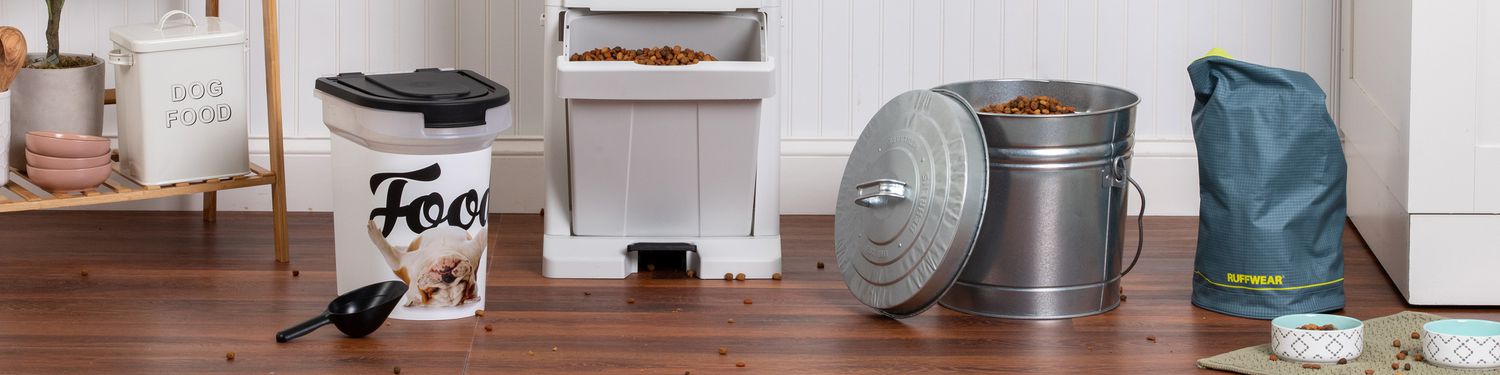 dog food containers and bins sit on top of a wood floor