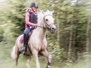 Teenage girl riding horse