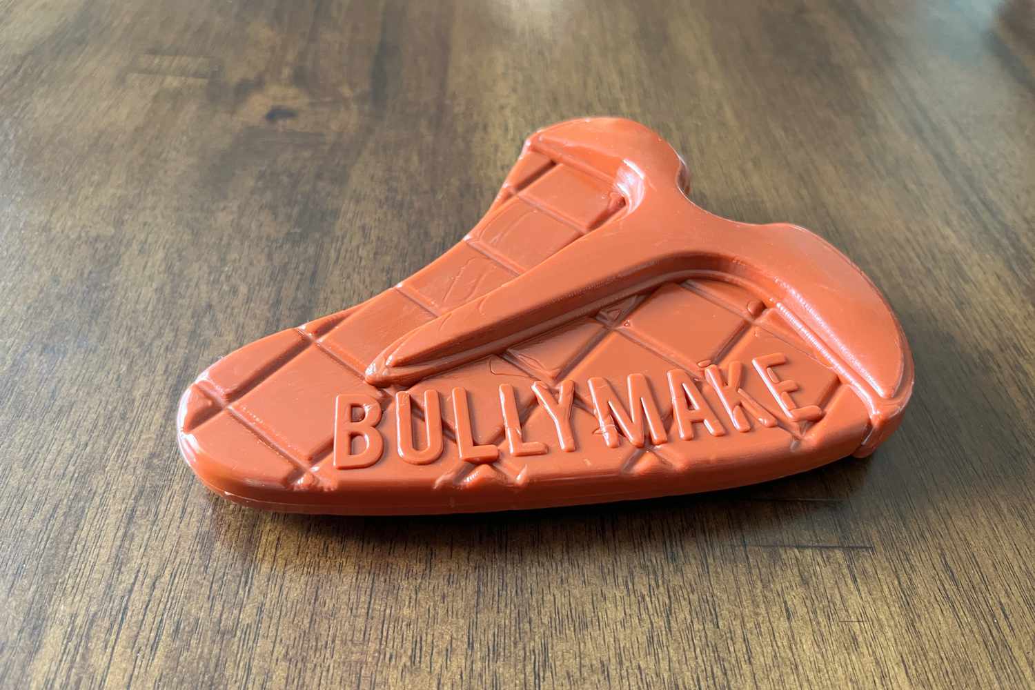 牛lymake Steak Dog Toy sitting on wood floor