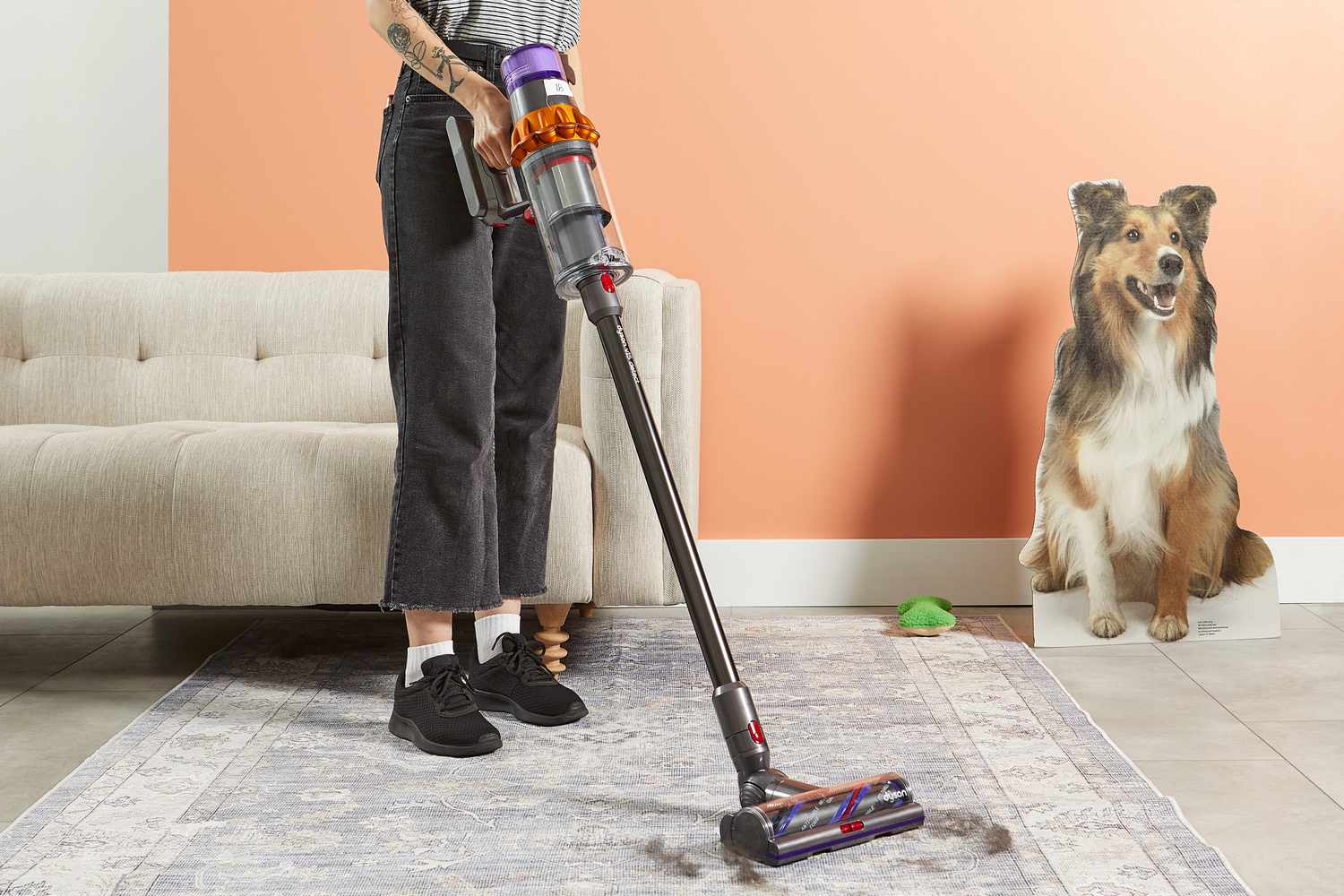 A person using a Dyson V15 Detect Cordless Vacuum Cleaner to clean fur off a rug