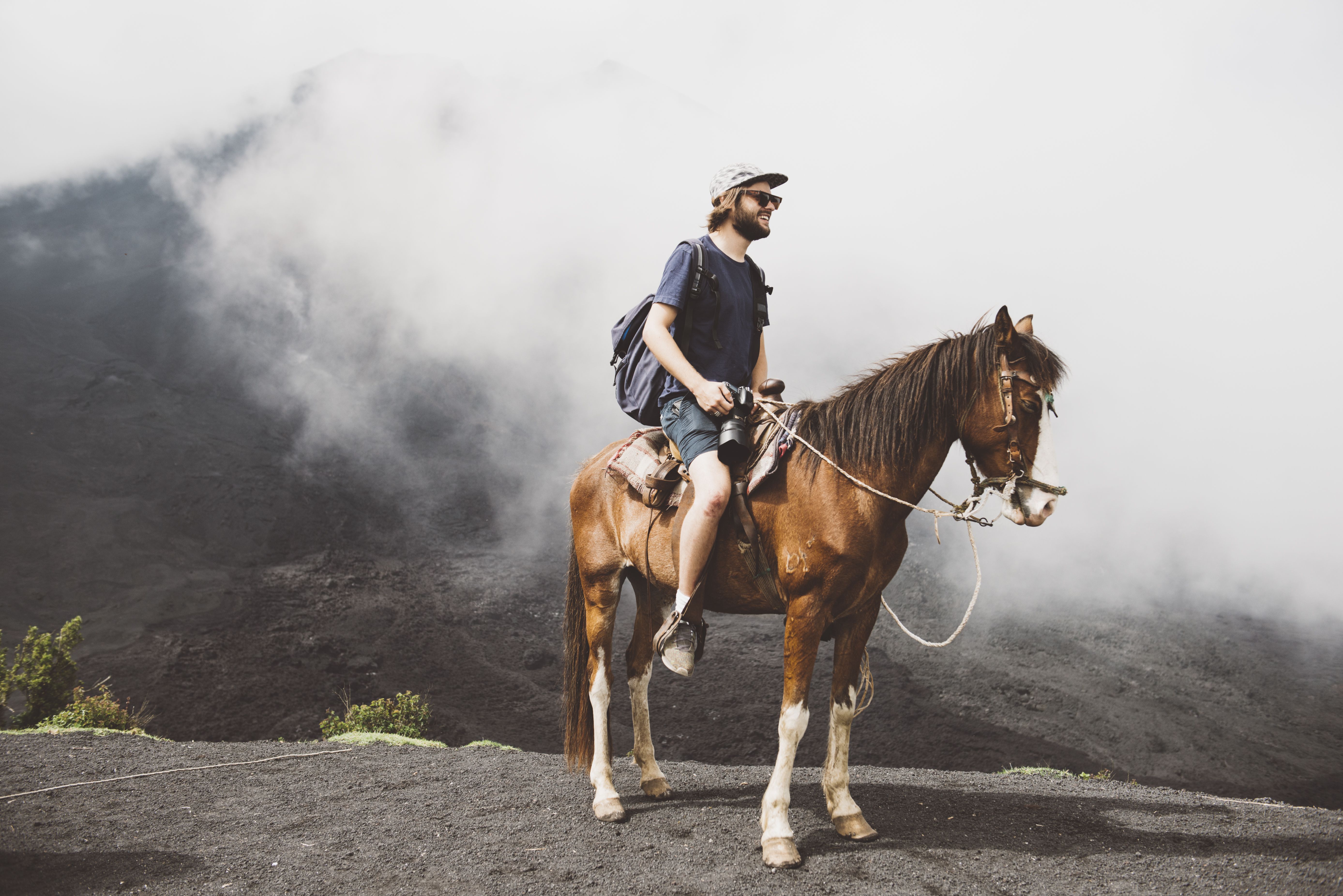 年轻人在危地马拉安提瓜的帕卡亚火山骑马徒步