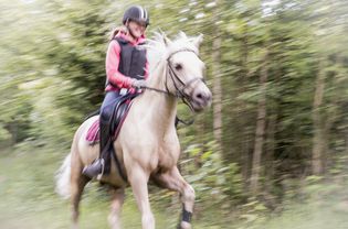 Teenage girl riding horse