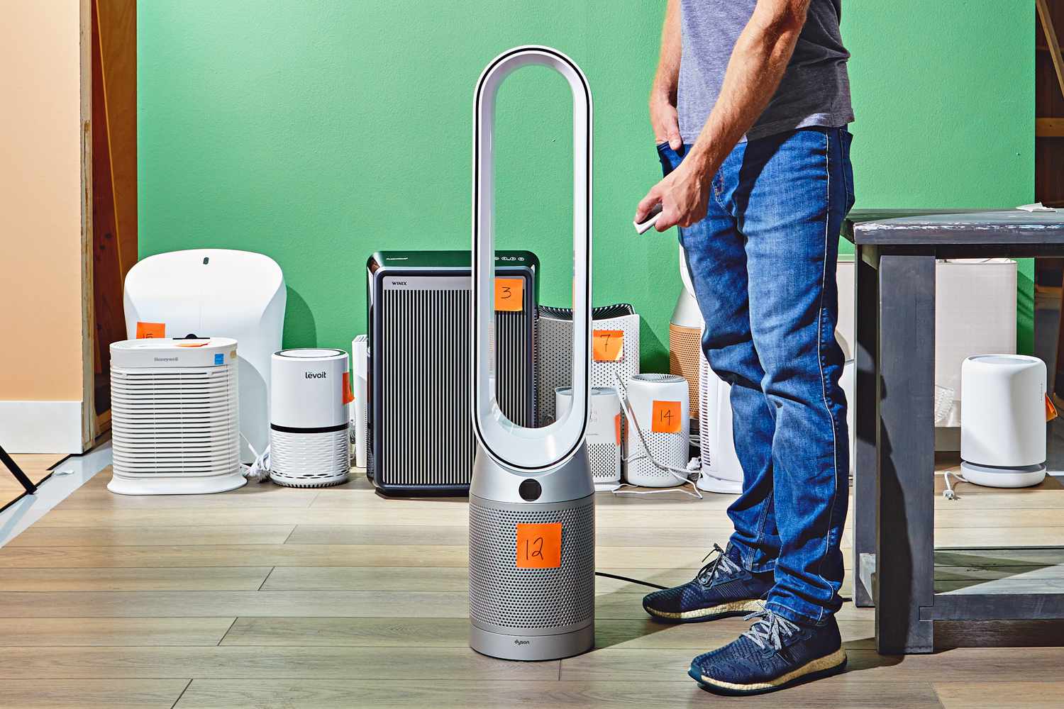 Person pressing remote button while standing next to Dyson Purifier Cool Purifying Fan TP07